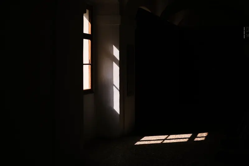 Pièce sombre éclairée par une fenêtre